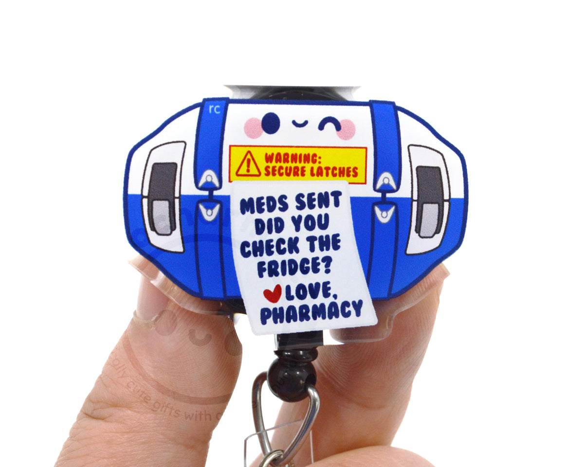 A person's hand holding a blue and white keychain with a humorous message printed on it.