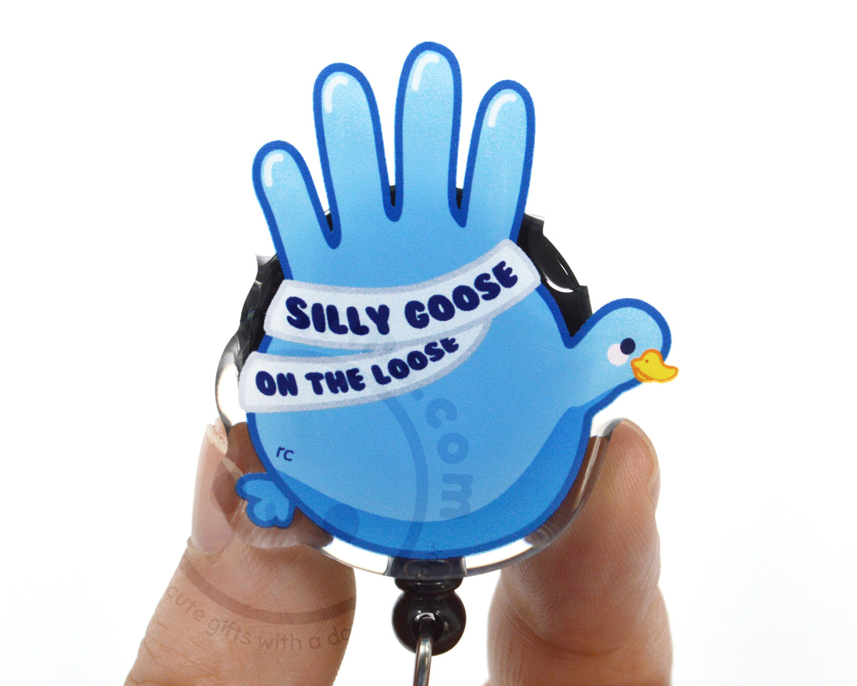 A person's hand holding a blue bird-shaped lanyard with the text "Silly goose on the loose" printed on it.