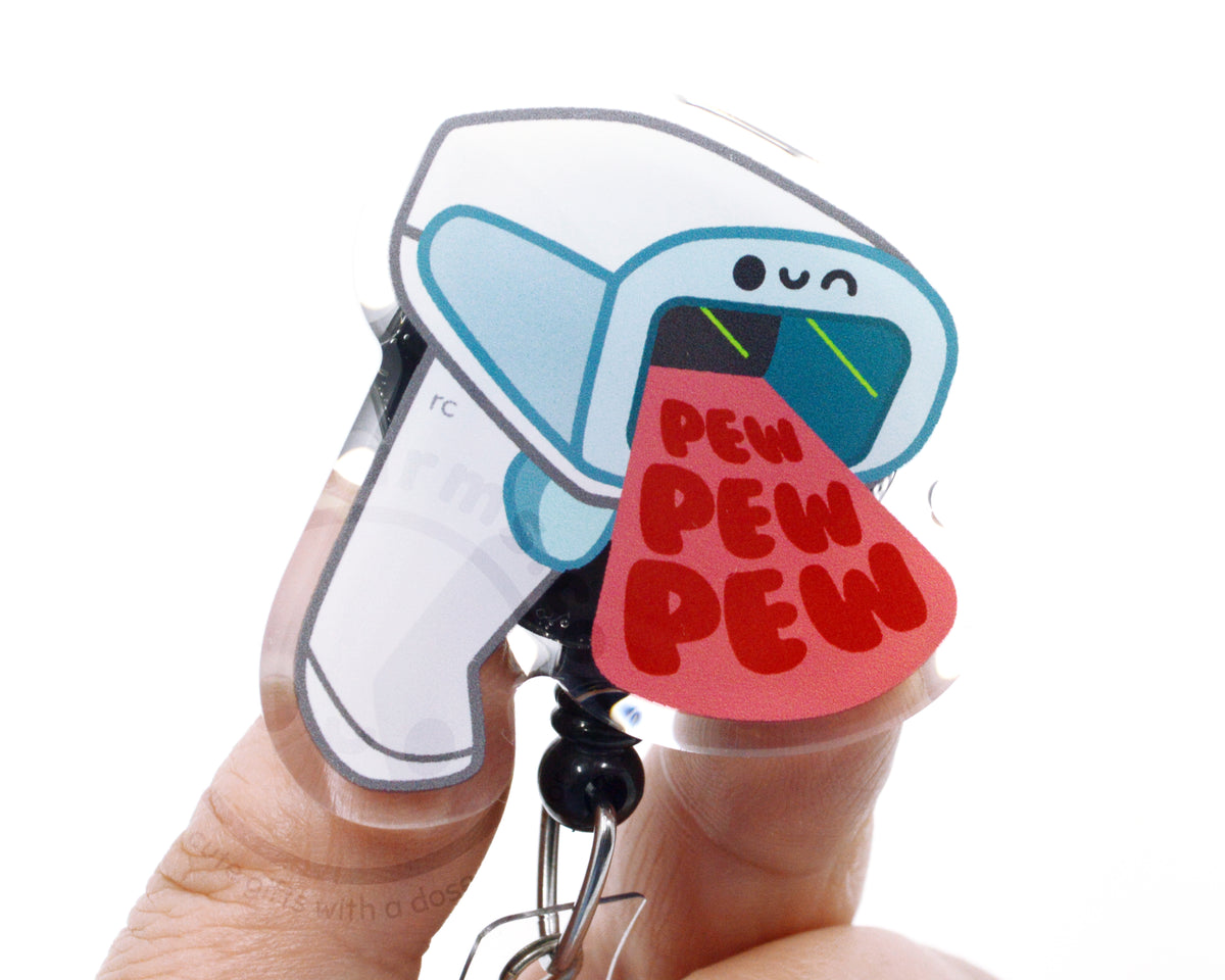 A person's hand holding a keychain with a cartoon image of a person's tongue sticking out and the text "PEW PEW PEW" written on it.